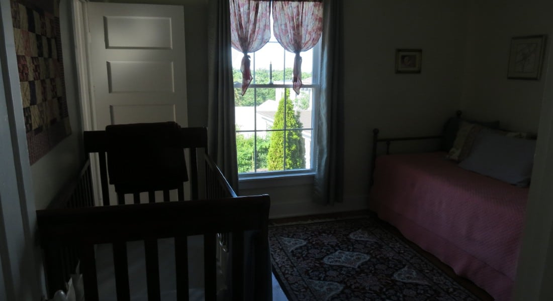 Twin bed with sunny window and a crib