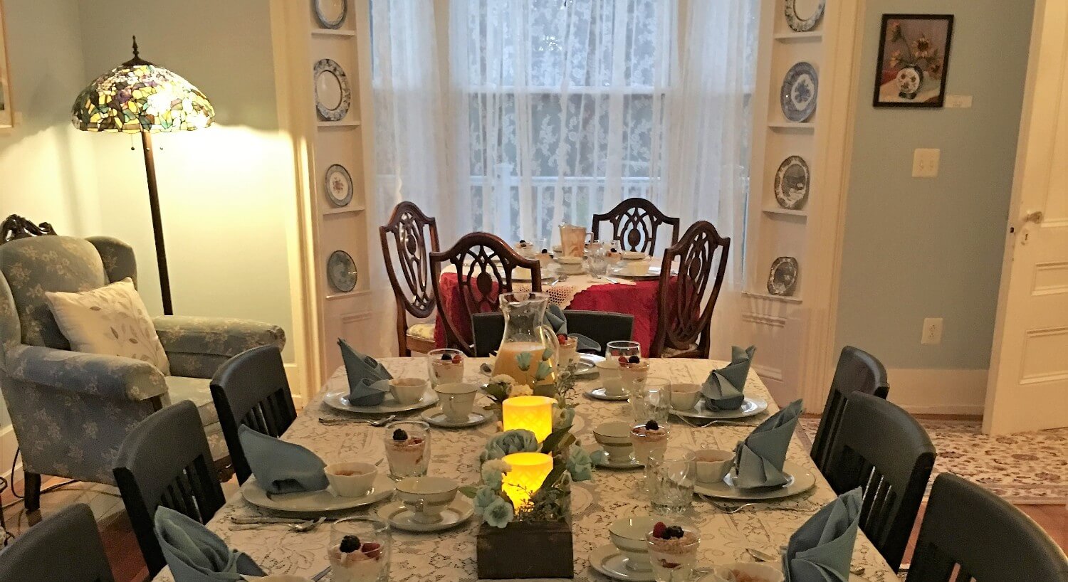 Long dining room table set for breakfast with china and folded napkins.